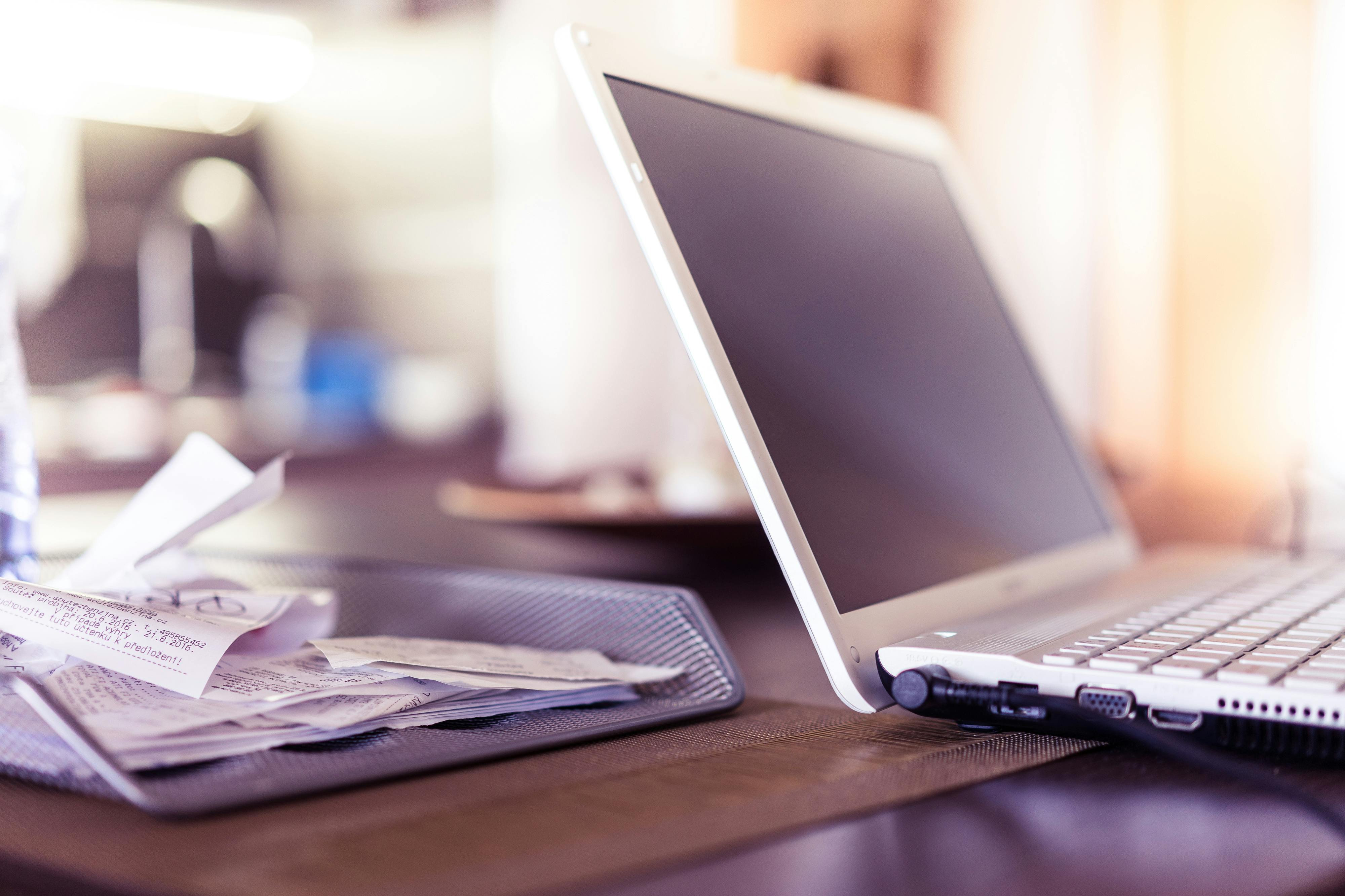 Receipts next to laptop for manual expense capturing