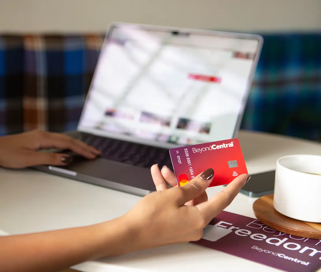 Employee using a PayCentral prepaid card while managing travel expenses on a laptop